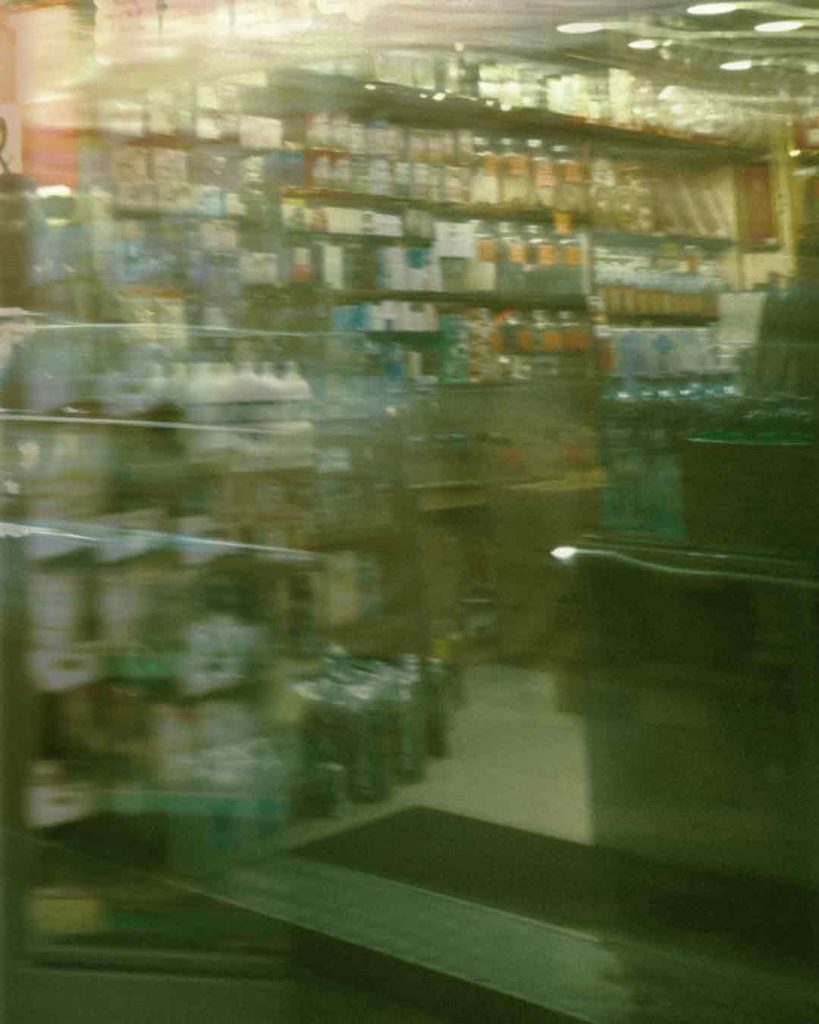 Blurred motion inside a supermarket aisle filled with packaged products.